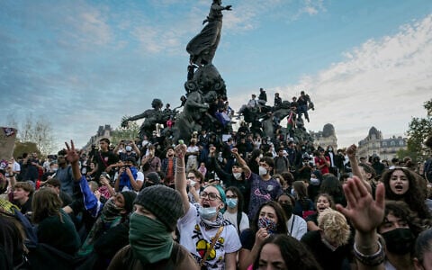 People gather on and around the statue in the center of the Place de la Republic square at the end of a demonstration part of a nationwide day of actions called by high-school students, joined by unions and teachers, who for days have been demanding better learning conditions in protests punctuated by violent confrontations in Paris on October 6, 2026. (Dimitar DILKOFF/AFP)