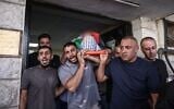 Mourners carry the body of Palestinian security officer Ali al-Bazari at Rafidia Hospital in the West Bank city of Nablus, after he was killed in a clash in the village of Burqa on October 7, 2026. (Zain JAAFAR / AFP)