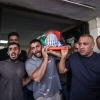 Mourners carry the body of Palestinian security officer Ali al-Bazari at Rafidia Hospital in the West Bank city of Nablus, after he was killed in a clash in the village of Burqa on October 7, 2026. (Zain JAAFAR / AFP)