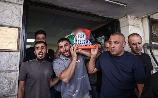 Mourners carry the body of Palestinian security officer Ali al-Bazari at Rafidia Hospital in the West Bank city of Nablus, after he was killed in a clash in the village of Burqa on October 7, 2026. (Zain JAAFAR / AFP)