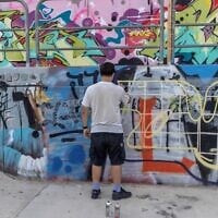 An Israeli youth makes a graffiti at a skatepark in Tel Aviv, September 29, 2026. (Ilia YEFIMOVICH/AFP)