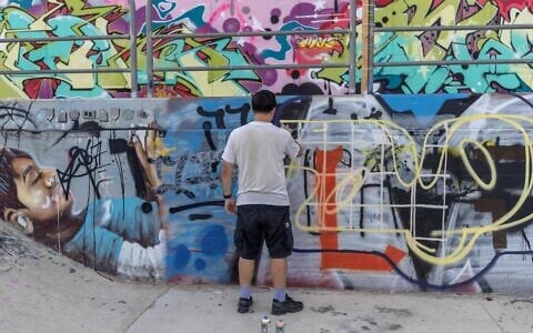 An Israeli youth makes a graffiti at a skatepark in Tel Aviv, September 29, 2026. (Ilia YEFIMOVICH/AFP)