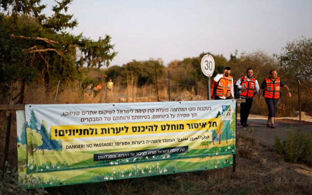 Medical personnel walk past a banner saying entry for hikers is banned, near the site of an explosion of an unexploded Hezbollah munition during a school hike on the outskirts of Yiftah near the Lebanese border, in northern Israel, October 12, 2026. (Jalaa MAREY/AFP) Medical personnel walk past a banner saying entry for hikers is banned, near the site of an explosion of an unexploded Hezbollah munition during a school hike on the outskirts of Yiftah near the Lebanese border, in northern Israel, October 12, 2026. (Jalaa MAREY/AFP)