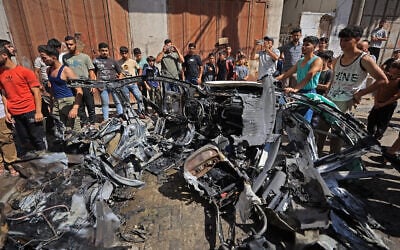Palestinians inspect the wreckage of a car after it was destroyed in Israeli strike at the Tuffah neighborhood of Gaza City on October 13, 2026. (Omar AL-QATTAA/AFP) Palestinians inspect the wreckage of a car after it was destroyed in Israeli strike at the Tuffah neighborhood of Gaza City on October 13, 2026. (Omar AL-QATTAA/AFP)