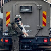 Illustrative: IDF soldier carries part of a memorial that was dedicated to Palestinians accused of killing Israelis or who died in clashes, during a military operation at the Jalazun camp for Palestinian refugees north of Ramallah in the West Bank on October 14, 2026. (Zain JAAFAR/AFP)