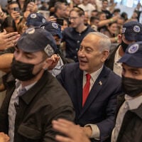 Prime Minister Benjamin Netanyahu stands amid security personnel as he meets with voters at a mall in Ramle on October 19, 2026. (ilia YEFIMOVICH/AFP)