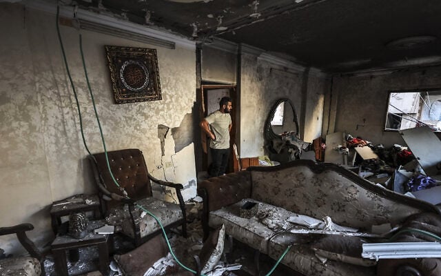 A man inspects the damage following an Israeli strike on a building that killed two people in Gaza City on October 20, 2026. (Omar AL-QATTAA/AFP)