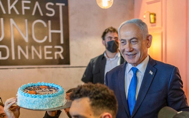 Prime Minister Benjamin Netanyahu (R) interacts with supporters who brought him a cake to celebrate his 77th birthday during a Likud Party meet-and-greet organized as part of the campaign ahead of the Knesset election, at a cafe inside a mall in Dimona on October 21, 2026. (Ilia YEFIMOVICH/AFP)