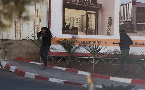 Two Palestinian gunmen amid an exchange fire with Israeli troops after a shooting attack at a checkpoint near Hebron, in the West Bank, on October 23, 2026. (HAZEM BADER/AFP)