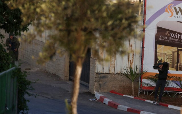 An IDF troop (L) and a Palestinian gunman (R) amid a gun battle after two Palestinians opened fire at a checkpoint near Hebron in the West Bank on on October 23, 2026. (HAZEM BADER/AFP)