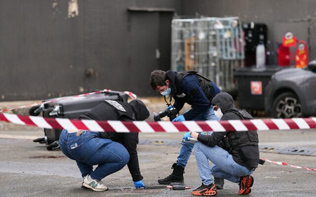 Police officers look at evidences on a site of a petrol station where a man opened fire from his car, killing one person and injuring four others according to police sources, in Trappes, Paris’ suburb on October 23, 2026. (Dimitar DILKOFF/AFP)