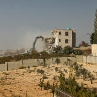 Israeli bulldozers demolish a Palestinian building in the West Bank city of Hebron on October 23, 2026. (HAZEM BADER/AFP)