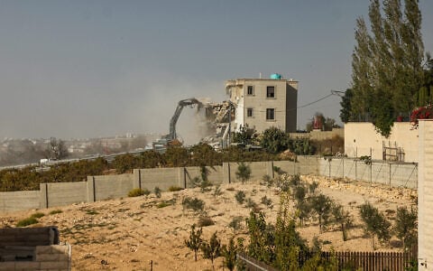 Israeli bulldozers demolish a Palestinian building in the West Bank city of Hebron on October 23, 2026. (HAZEM BADER/AFP)