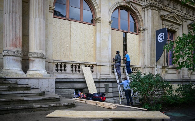 Workers install plywood boards on windows of the Chamber of Commerce and Industry in Lyon, on October 23, 2026 ahead of protests. (OLIVIER CHASSIGNOLE/AFP) Workers install plywood boards on windows of the Chamber of Commerce and Industry in Lyon, on October 23, 2026 ahead of protests. (OLIVIER CHASSIGNOLE/AFP)
