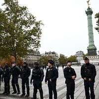 Police officers stand guard at the Place de la Bastille with The July Column in the background ahead of a demonstration in Paris on October 24, 2026 (Aris MESSINIS/AFP)