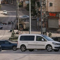 An Israeli bulldozer is seen on a street that has been apparently been blocked by Israeli security forces using cars owned by Palestinians in the West Bank city of Hebron on October 25, 2026. (HAZEM BADER/AFP)