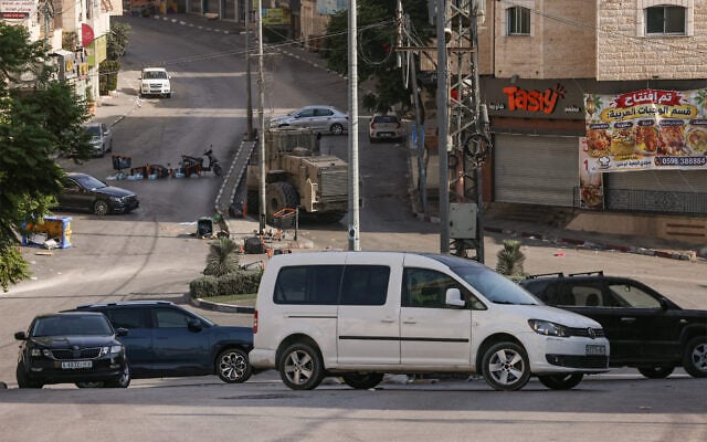 An Israeli bulldozer is seen on a street that has been apparently been blocked by Israeli security forces using cars owned by Palestinians in the West Bank city of Hebron on October 25, 2026. (HAZEM BADER/AFP)