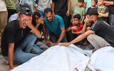 Mourners grieve next to the bodies of three Palestinians during their funeral at Al-Shifa Hospital in Gaza City on October 25, 2026, after they were reportedly killed in an Israeli strike on the Islamic University building. (Omar AL-QATTAA/AFP)