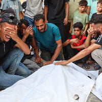 Mourners grieve next to the bodies of three Palestinians during their funeral at Al-Shifa Hospital in Gaza City on October 25, 2026, after they were reportedly killed in an Israeli strike on the Islamic University building. (Omar AL-QATTAA/AFP)