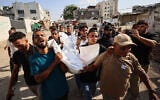 Mourners carry the body of one of three Palestinians during their funeral at Shifa Hospital in Gaza City on October 25, 2026, after they were killed in an Israeli strike on the Islamic University building. (Omar AL-QATTAA/AFP)