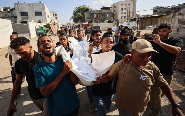 Mourners carry the body of one of three Palestinians during their funeral at Shifa Hospital in Gaza City on October 25, 2026, after they were killed in an Israeli strike on the Islamic University building. (Omar AL-QATTAA/AFP)