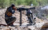 A fighter loyal to Yemen’s internationally-recognized government fires a machine gun balanced on a motorcycle at a position along the frontlines against the Houthis around Mount al-Midan in Yemen’s western Taiz province on October 26, 2026. (Ahmad AL-BASHA/AFP)