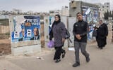 Palestinians walk past campaign posters for far-right politician Itamar Ben Gvir, in Beit Kahil in the West Bank during Israeli general elections on October 27, 2026. (Ilia Yefimovich/AFP)
