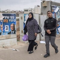Palestinians walk past campaign posters for far-right politician Itamar Ben Gvir, in Beit Kahil in the West Bank during Israeli general elections on October 27, 2026. (Ilia Yefimovich/AFP)