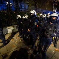 Police officers stand on alert as protesters gather outside the headquarters of Poland’s Constitutional Court in Warsaw after police blocked access to the building on October 30, 2026. (Wojtek RADWANSKI/AFP)