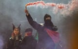 Protesters light smoke flares after a demonstration organised by “GenZ regelt!” (Gen Z has got this!) in Berlin on October 31, 2026. (RALF HIRSCHBERGER/AFP)