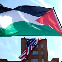 A giant American flag is unfurled on Lisner Hall on the campus of George Washington University in Washington, May 3, 2024, as demonstrators protest the Israel-Hamas war. (AP Photo/Susan Walsh)