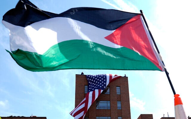 A giant American flag is unfurled on Lisner Hall on the campus of George Washington University in Washington, May 3, 2024, as demonstrators protest the Israel-Hamas war. (AP Photo/Susan Walsh)
