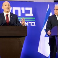 Naftali Bennett, left, and Yair Lapid hold a joint press conference announcing they will run together in the upcoming elections, in Herzliya, April 26, 2026. (AP Photo/Ariel Schalit)