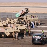 Saudi military personnel and visitors gather near armored vehicles on display before the start of an air show and military parade marking Saudi National Day in Malham, north of Riyadh, Saudi Arabia, September 22, 2026. (AP Photo/Baraa Anwer)