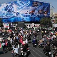 Motorcyclists drive past a billboard depicting a Persian legendary hero and flying figure hitting US aircraft carriers alongside the message in English and Farsi: “From the Persian Gulf a new power rises,” “The army of Satan will be drowned in the Persian Gulf," during a state-organized motorcycle parade called “Janfada,” meaning “Sacrifice for Iran,”, in Tehran, Iran, September 25, 2026. (AP Photo/Vahid Salemi)