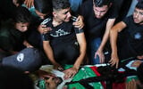 Palestinians mourn around the body of Hamas militant Izz al-Din al-Bik, draped in the group’s flag with a rifle placed on top, during his funeral after he was killed in an Israeli airstrike in Gaza City, September 29, 2026. (AP Photo/Jehad Alshrafi)