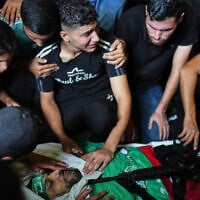 Palestinians mourn around the body of Hamas militant Izz al-Din al-Bik, draped in the group’s flag with a rifle placed on top, during his funeral after he was killed in an Israeli airstrike in Gaza City, September 29, 2026. (AP Photo/Jehad Alshrafi)
