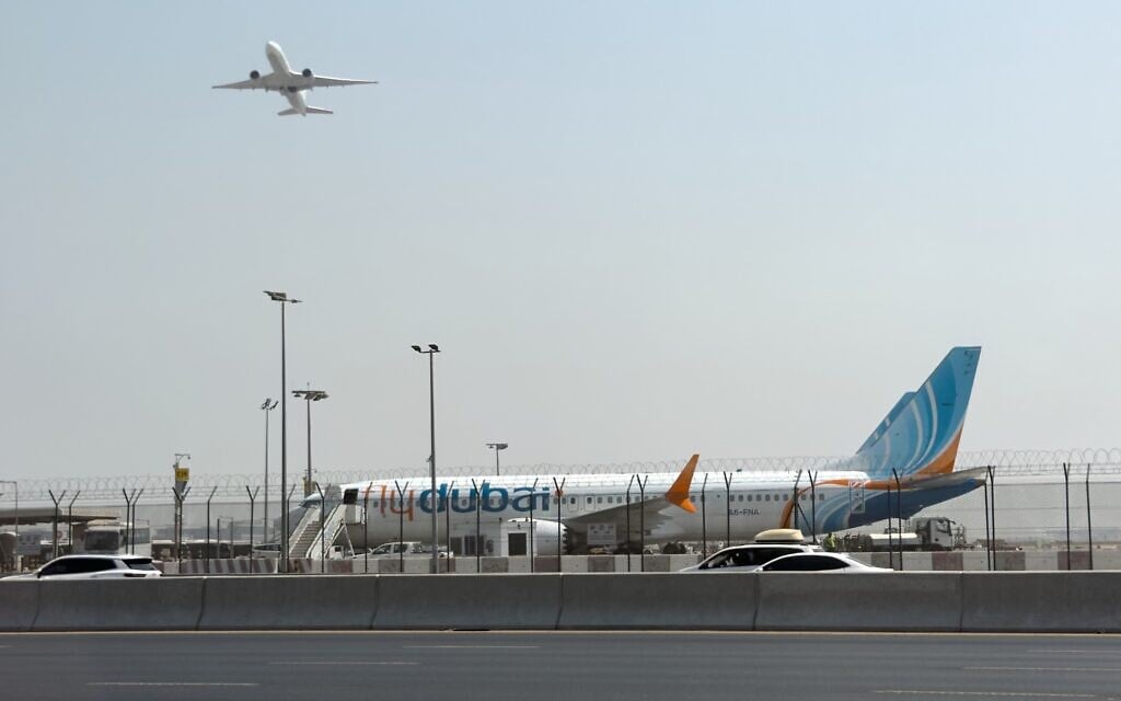 A plane takes off as a flydubai aircraft sits on the tarmac at Dubai International Airport in Dubai, United Arab Emirates, September 30, 2026. (AP Photo)