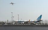 A plane takes off as a flydubai aircraft sits on the tarmac at Dubai International Airport in Dubai, United Arab Emirates, September 30, 2026. (AP Photo)