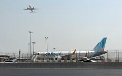 A plane takes off as a flydubai aircraft sits on the tarmac at Dubai International Airport in Dubai, United Arab Emirates, September 30, 2026. (AP Photo)