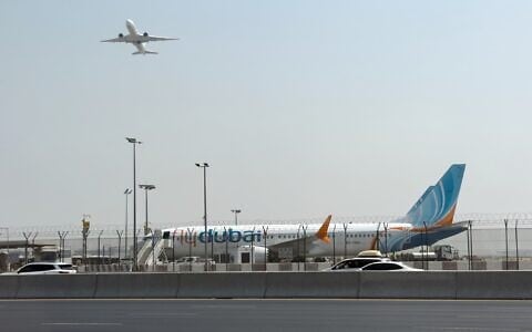 A plane takes off as a flydubai aircraft sits on the tarmac at Dubai International Airport in Dubai, United Arab Emirates, September 30, 2026. (AP)