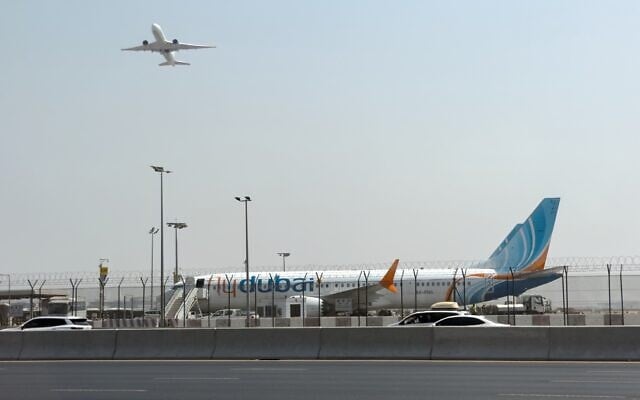 A plane takes off as a flydubai aircraft sits on the tarmac at Dubai International Airport in Dubai, United Arab Emirates, September 30, 2026. (AP Photo)