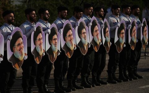 Members of Hezbollah’s al-Mahdi Scouts hold portraits of Hezbollah leaders Hassan Nasrallah and his cousin and successor, Hashem Safieddine, during a gathering marking the second anniversary of their killings in Israeli airstrikes, in Dahiyeh, a southern suburb of Beirut, Lebanon, October 4, 2026. (AP Photo/Hassan Ammar)