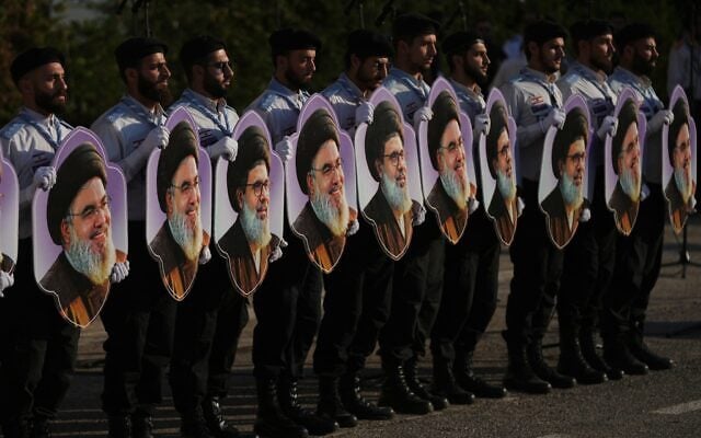 Members of Hezbollah’s al-Mahdi Scouts hold portraits of Hezbollah leaders Hassan Nasrallah and his cousin and successor, Hashem Safieddine, during a gathering marking the second anniversary of their killings in Israeli airstrikes, in Dahiyeh, a southern suburb of Beirut, Lebanon, October 4, 2026. (AP Photo/Hassan Ammar)