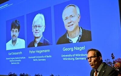 Karl Deisseroth, Peter Hegemann and Georg Nagel are shown on the screen as they are awarded the 2026 Nobel Prize in Physiology or Medicine, as announced during a press conference at the Nobel Forum at Karolinska Institutet in Stockholm, Sweden, October 5, 2026. (Pontus Lundahl/TT News Agency via AP)