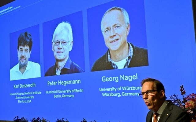 Karl Deisseroth, Peter Hegemann and Georg Nagel are shown on the screen as they are awarded the 2026 Nobel Prize in Physiology or Medicine, as announced during a press conference at the Nobel Forum at Karolinska Institutet in Stockholm, Sweden, October 5, 2026. (Pontus Lundahl/TT News Agency via AP)