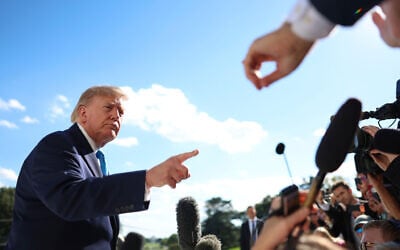 US President Donald Trump gestures as he speaks to reporters before boarding Marine One on the South Lawn of the White House, October 5, 2026, in Washington. (AP Photo/Tom Brenner)