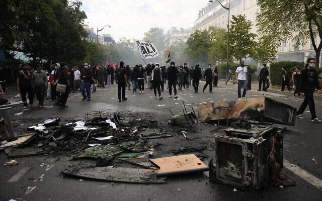 Protesters walk past burned garbages after a demonstration against under-resourced schools, in Paris, October 6, 2026. (AP Photo/Teresa Suarez) Protesters walk past burned garbages after a demonstration against under-resourced schools, in Paris, October 6, 2026. (AP Photo/Teresa Suarez)