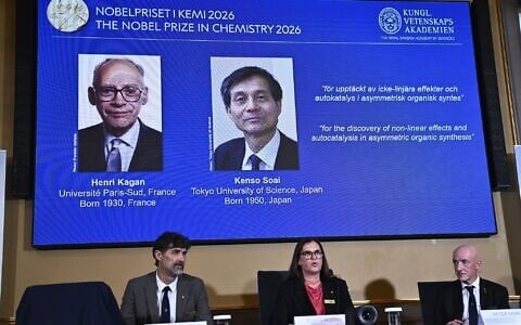 Portraits of Henri Kagan and Kenso Soai are shown on the screen as they are awarded the 2026 Nobel Prize in Chemistry, at the Royal Swedish Academy of Sciences in Stockholm, Sweden, on October 7, 2026. (Fredrik Sandberg/TT News Agency via AP)