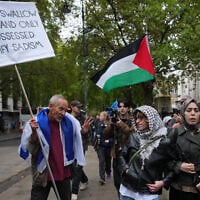 Pro-Palestinian, anti-Israel protesters encounter a pro-Israel protester during a march in London marking three years since 2023's Hamas-led invasion and massacre in Israel, October 7, 2026. (AP Photo/Kin Cheung)
